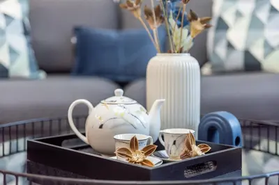 a coffee table with a tray with tea cups and a vase at GuestReady - Elegant 1BR w/ Balcony | Dubai Marina in Dubai