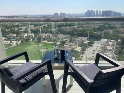 a balcony with two chairs and a table with a view at Big studio, Dubai SportCity, parking included in Dubai
