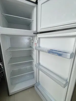 an empty refrigerator with its door open in a kitchen at Big studio, Dubai SportCity, parking included in Dubai