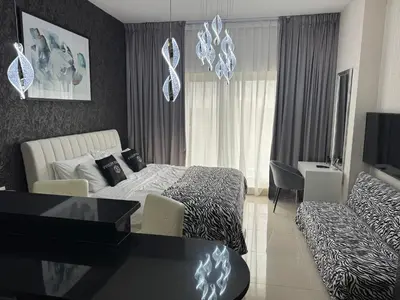 a bedroom with a bed and a living room at Big studio, Dubai SportCity, parking included in Dubai