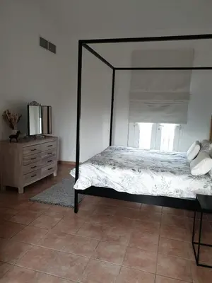 a bedroom with a black canopy bed and a dresser at Cherrywood House in Dubai