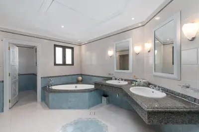 a bathroom with two sinks and two mirrors at Palm Jumeirah - Property Advisers in Dubai