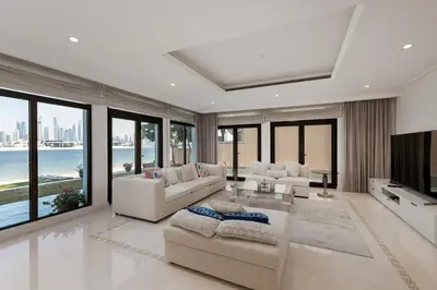 a living room with white furniture and large windows at Palm Jumeirah - Property Advisers in Dubai