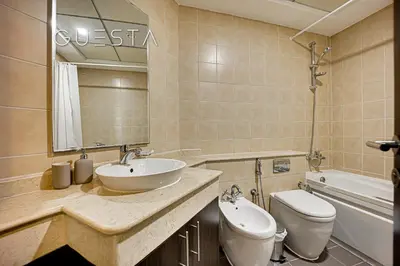 a bathroom with a sink and a toilet and a mirror at The Torch, Dubai Marina in Dubai