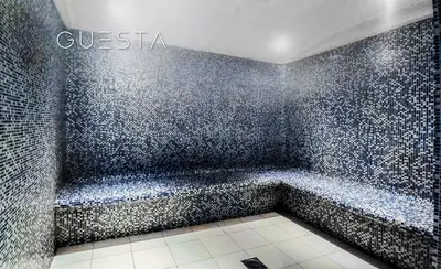 a bathroom with a bath tub with a tiled wall at The Torch, Dubai Marina in Dubai