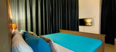 a bedroom with a bed with blue sheets and a television at 2 BR apartment with a beautiful view of the Marina minimum 5 night in Dubai