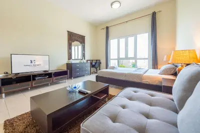 a large living room with a bed and a tv at Luxury Escapes - Stylish Studio in DG near to Mall & Metro - KSLV in Dubai
