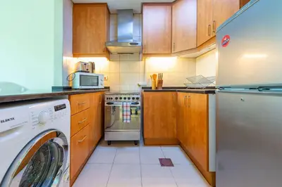 a kitchen with a washer and a dishwasher in it at Luxury Escapes - Stylish Studio in DG near to Mall & Metro - KSLV in Dubai