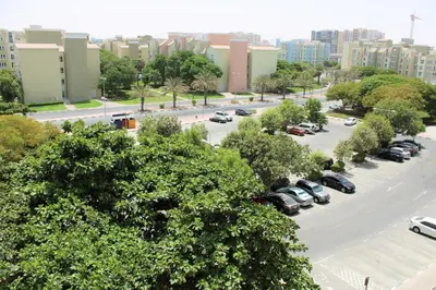 a city street with cars parked in a parking lot at Luxury Escapes - Stylish Studio in DG near to Mall & Metro - KSLV in Dubai