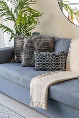 a blue couch with pillows and a plant on it at Frank Porter - Bay Central in Dubai