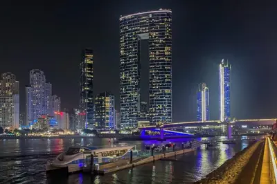 a boat docked at a dock in a city at night at Frank Porter - The Address JBR in Dubai