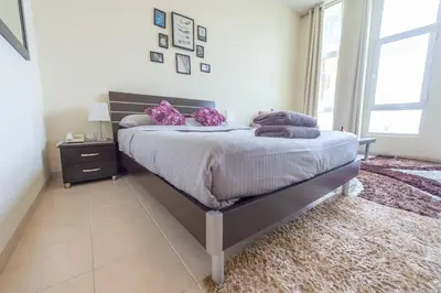 a bedroom with a bed with purple pillows on it at Luxury Escapes - Tranquil Retreat - Studio Apts near Metro and Mall - Discovery Gardens - SHAR & MCL in Dubai