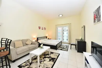 a living room with a couch and a table at Luxury Escapes - Budget Studio with Garden Views near Metro - MED64 DG in Dubai