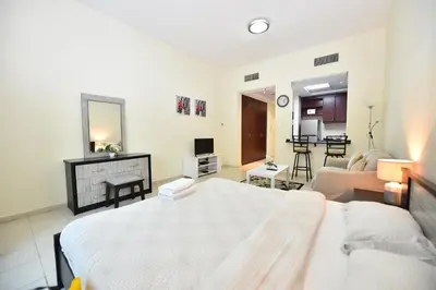a bedroom with a bed and a living room at Luxury Escapes - Budget Studio with Garden Views near Metro - MED64 DG in Dubai