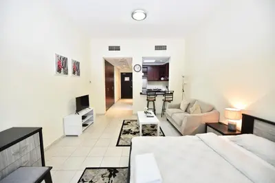 a living room with a couch and a table at Luxury Escapes - Budget Studio with Garden Views near Metro - MED64 DG in Dubai