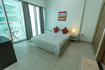 a bedroom with a bed and a large window at Deluxe One Bedroom Apartment for rent in Dubai Al Barsha south in Dubai