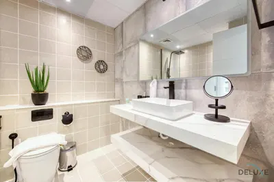 a bathroom with a sink and a mirror and a toilet at Elegant 2BR at The Point Dubai Marina by Deluxe Holiday Homes in Dubai
