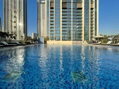 a large swimming pool with tall buildings in the background at GuestReady - The Ivory Coast Downtown Views in Dubai