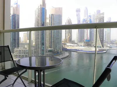 a balcony with a table and chairs and a view of a city at Luxury Escapes - 1BR with Balcony & Stunning Marina View - MVT in Dubai