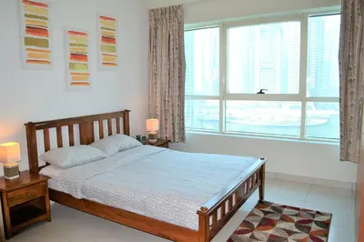 a bedroom with a bed and a large window at Luxury Escapes - 1BR with Balcony & Stunning Marina View - MVT in Dubai