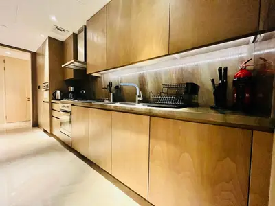 a kitchen with wooden cabinets and stainless steel appliances at FIVE Palm Jumeirah - 2 Bedrooms & Maid Room Apartment in a Splendid Resort in Dubai