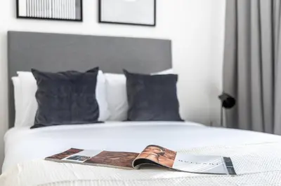 a bed with a magazine and a shoe on it at Silkhaus stunning studio in central DIFC with balcony in Dubai