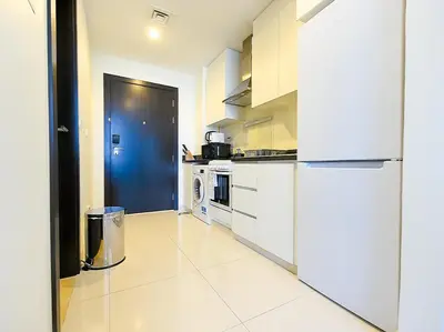 a kitchen with white appliances and a blue door at Luxury Escapes - Quiet Studio near Expo City and DWC Airport - CELESTIA TOWER in Dubai