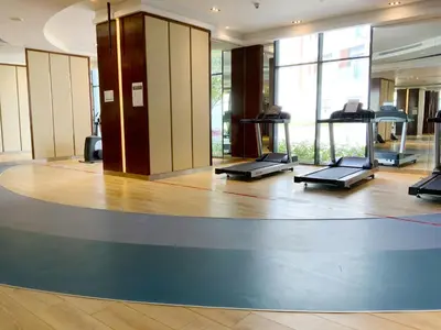 a gym with a row of treadmills on the floor at Luxury Escapes - Quiet Studio near Expo City and DWC Airport - CELESTIA TOWER in Dubai