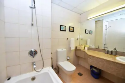 a bathroom with a tub and a toilet and a sink at Luxury Escapes - Stylish Studio Vacation Home near Metro - MOG189 DG in Dubai