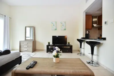 a living room with a couch and a table at Luxury Escapes - Stylish Studio Vacation Home near Metro - MOG189 DG in Dubai