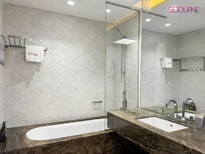 a bathroom with a tub and a sink and a shower at DH58 - High end 1BR, Palm views in Damac Heights tower in Dubai
