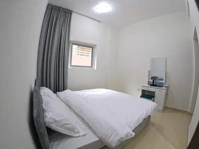 a bedroom with a white bed and a window at Karama Star Residence (Home Stay) in Dubai