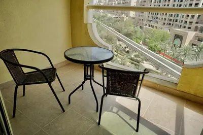 a table and two chairs in a room with a window at Luxury Apartment Palm Jumeirah in Dubai