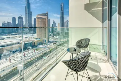 a balcony with two chairs and a view of a city at Elegant 2BR at Downtown Views Downtown Dubai by Deluxe Holiday Homes in Dubai