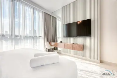 a bedroom with a bed and a tv on a wall at Elegant 2BR at Downtown Views Downtown Dubai by Deluxe Holiday Homes in Dubai
