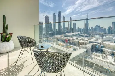 a balcony with two chairs and a view of a city at Elegant 2BR at Downtown Views Downtown Dubai by Deluxe Holiday Homes in Dubai