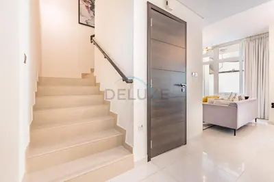 a door leading to a hallway with stairs in a house at Furnished 3-Bedroom Townhouse, Just Minutes Drive from Al Marmoom Heritage Village and Popular Dubai Attractions, Albizia, Damac Hills 2 by Deluxe Holiday Homes in Dubai