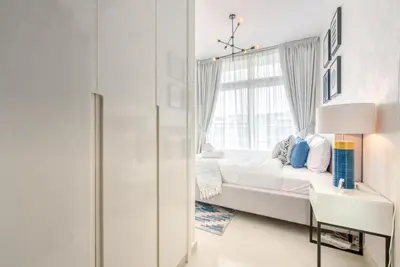 a white bedroom with a bed and a window at Spell-binding 3BR Townhouse at DAMAC Hills 2 Dubailand by Deluxe Holiday Homes in Dubai