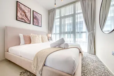 a bedroom with a bed and a large window at Spell-binding 3BR Townhouse at DAMAC Hills 2 Dubailand by Deluxe Holiday Homes in Dubai