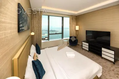 a hotel room with a bed and a television at The Palm Tower, Nakheel Mall, Palm Jumeirah in Dubai