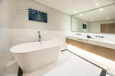 a bathroom with a large white tub and two sinks at The Palm Tower, Nakheel Mall, Palm Jumeirah in Dubai