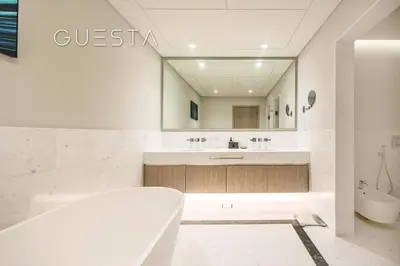 a bathroom with a tub and a large mirror at The Palm Tower, Nakheel Mall, Palm Jumeirah in Dubai
