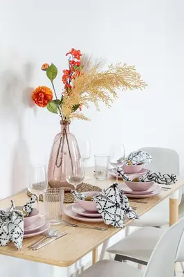 a dining room table with a vase with flowers in it at Frank Porter - Time Place in Dubai