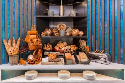 a shelf filled with lots of different types of bread at Taj Exotica Resort & Spa, The Palm, Dubai in Dubai