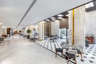 a lobby with tables and chairs in a building at Taj Exotica Resort & Spa, The Palm, Dubai in Dubai