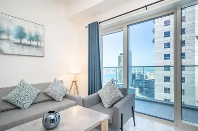 a living room with a couch and a large window at Stunning 1BR with Partial Sea View in Damac Heights, Dubai Marina-21AB03 in Dubai