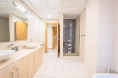a bathroom with two sinks and a shower at Premium 4BR Apt Pool Palm Beach Club Dubai in Dubai
