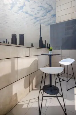 a balcony with two tables and a view of a city at Silkhaus modish studio with Burj Khalifa view, pool access in Dubai