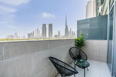a balcony with two chairs and a view of the city at Silkhaus modish studio with Burj Khalifa view, pool access in Dubai