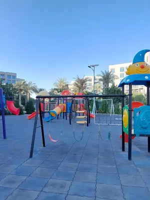 a playground with colorful swings and slides at Budget-friendly 2bd near EXPO with a huge pool in Dubai